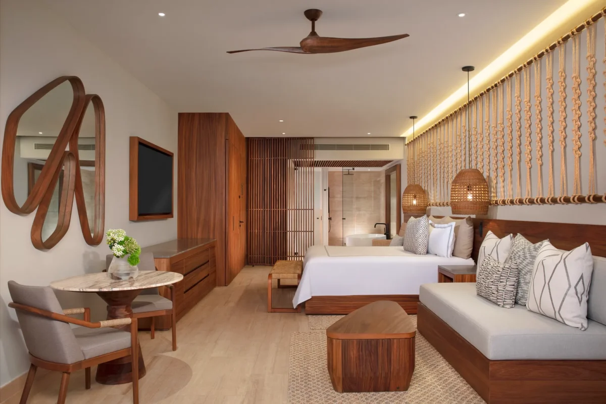 Junior Suite with king bed, sofa seating, and tropical décor at Secrets Playa Blanca Costa Mujeres.
