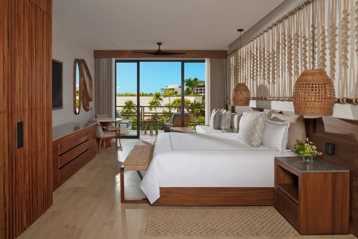 Junior Suite Tropical View with king bed and private balcony overlooking lush greenery at Secrets Playa Blanca Costa Mujeres.