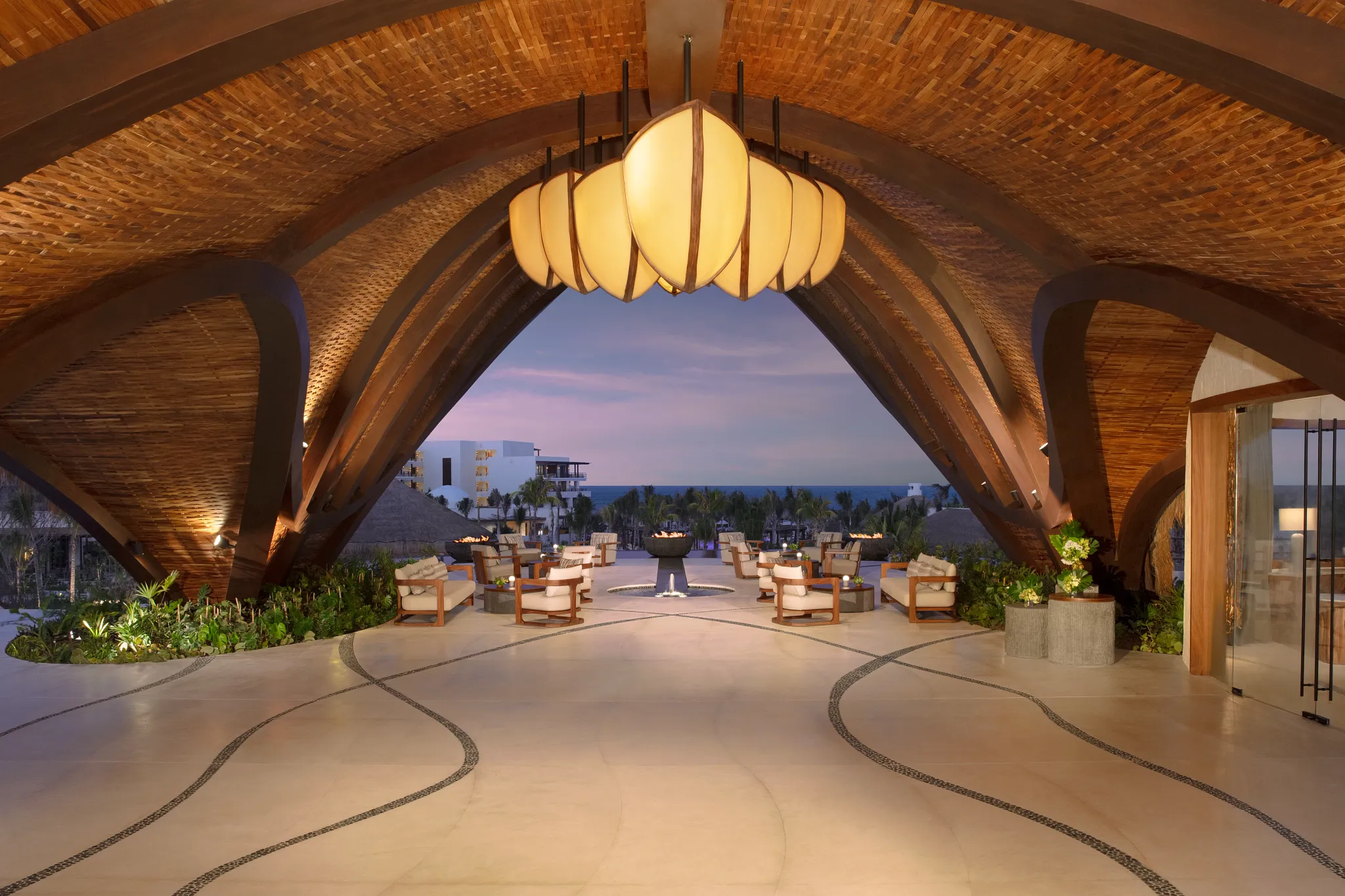Grand open-air lobby with wooden architecture and ocean view at Secrets Playa Blanca Costa Mujeres.