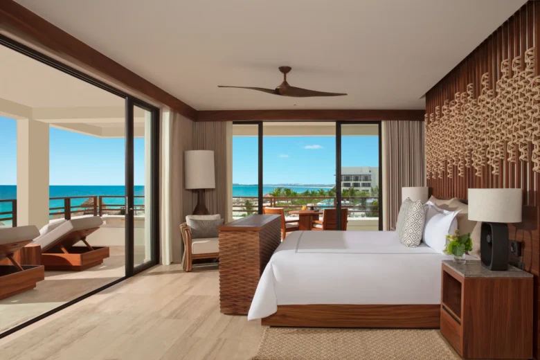 Corner oceanfront bedroom with king bed and wraparound balcony at Secrets Playa Blanca Costa Mujeres.