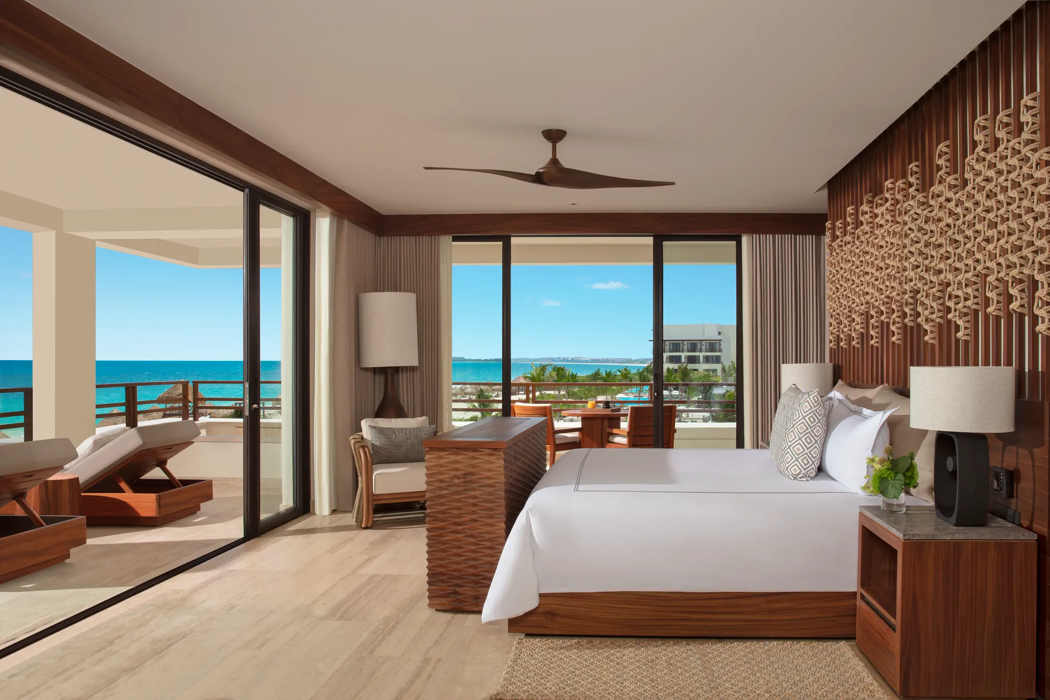 Corner oceanfront bedroom with king bed and wraparound balcony at Secrets Playa Blanca Costa Mujeres.