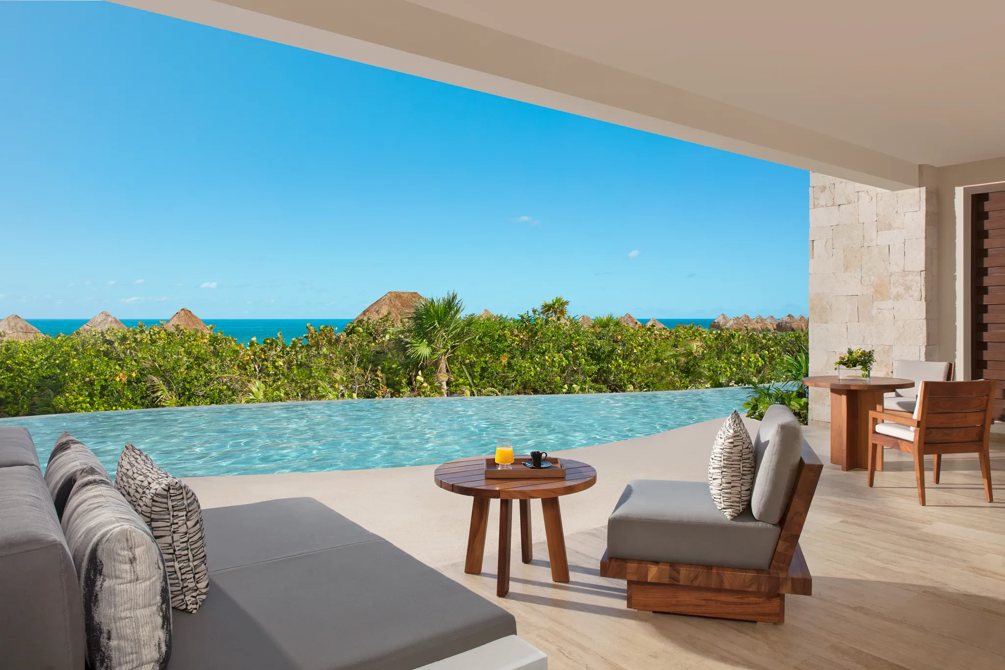 Oceanfront swim-out terrace with infinity-style pool and panoramic sea views at Secrets Playa Blanca Costa Mujeres.