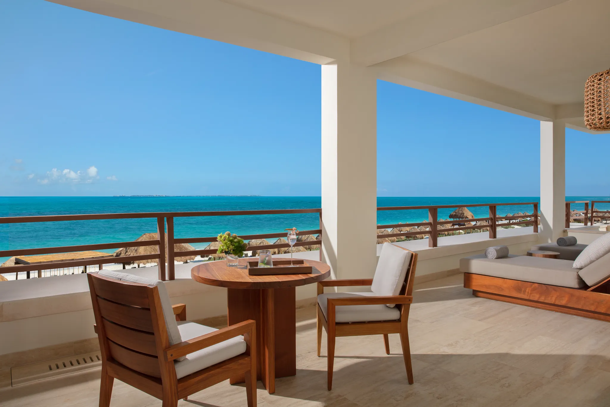 Corner oceanfront terrace with seating and panoramic sea views at Secrets Playa Blanca Costa Mujeres master suite.