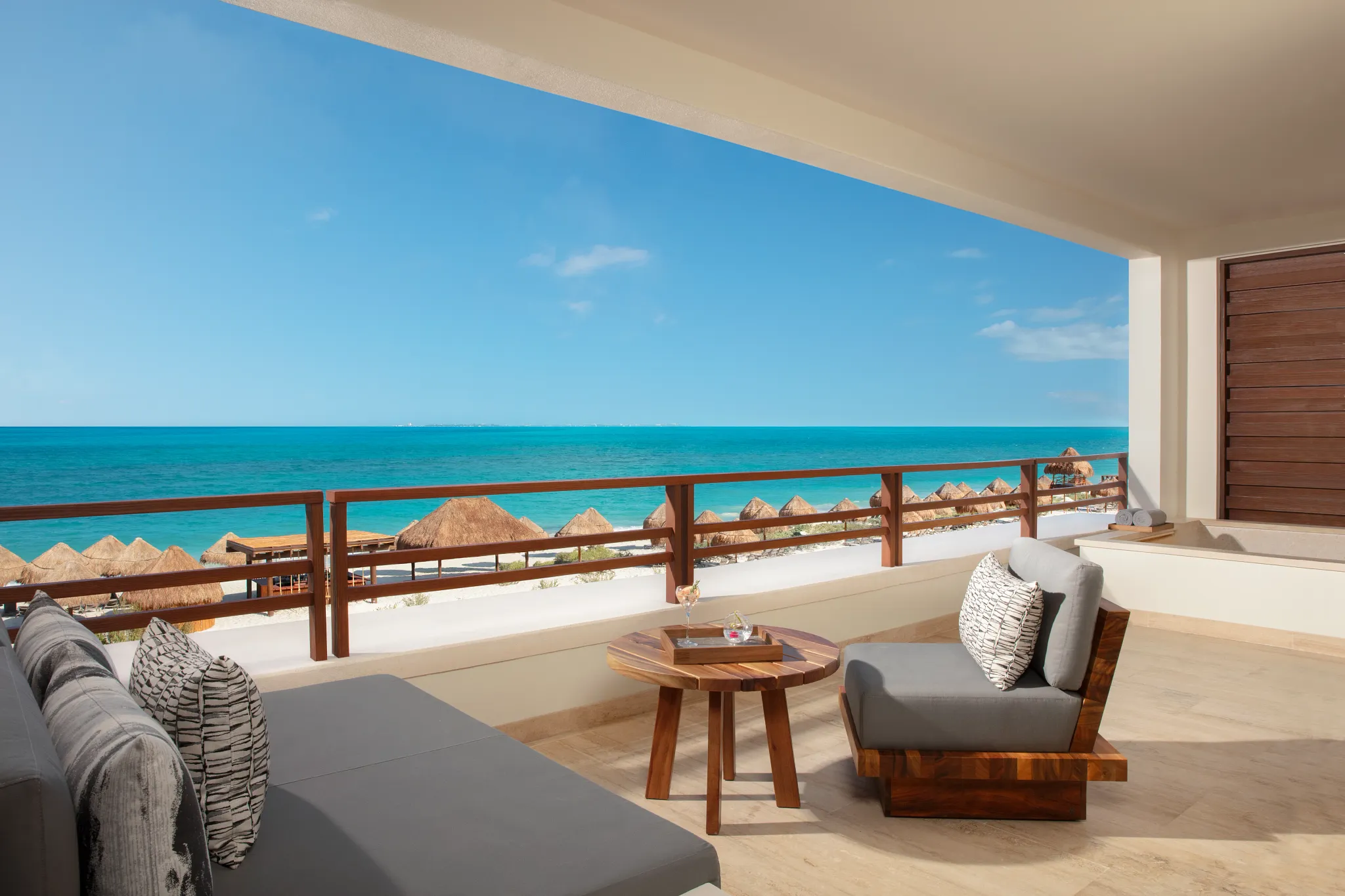 Oceanfront balcony with seating and outdoor tub at Secrets Playa Blanca Costa Mujeres Preferred Club Master Suite.
