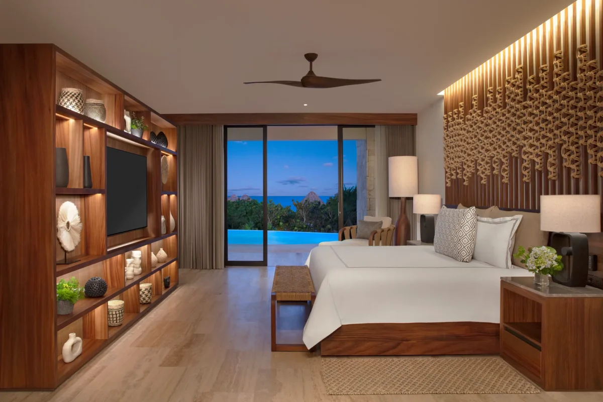 Oceanfront bedroom with king bed and swim-out pool view in Preferred Club Master Suite at Secrets Playa Blanca.
