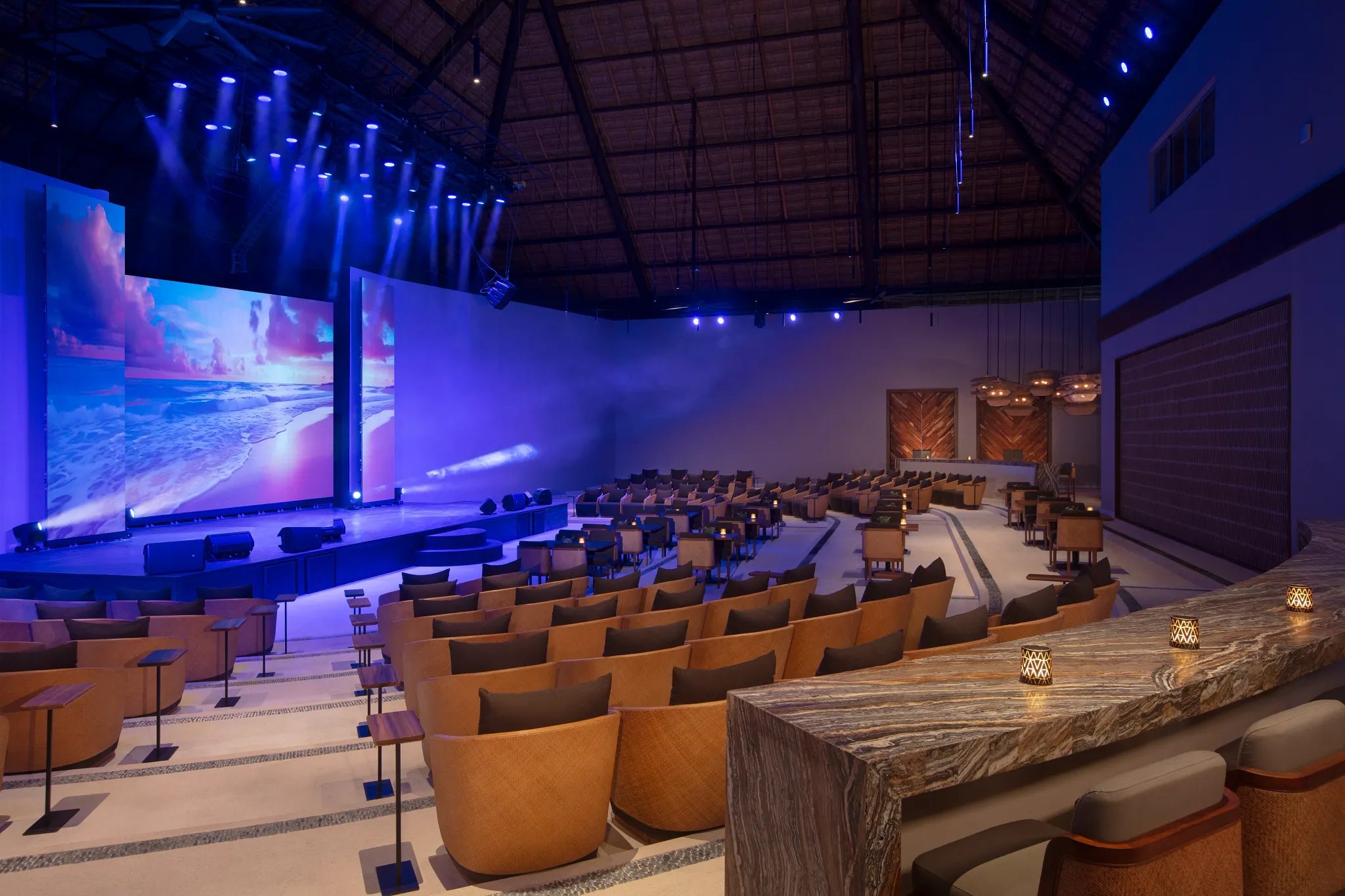 Indoor entertainment theater with stage lighting and seating at Secrets Playa Blanca Costa Mujeres.